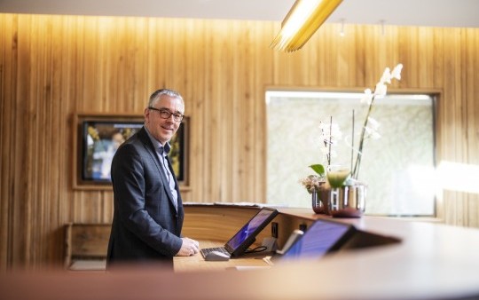 The reception manager of the four-star Hotel Jagdhaus Wiese in the Sauerland at the new reception desk.