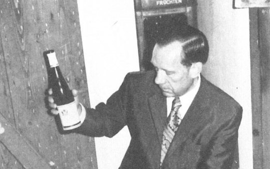 Hotelmanager Clemens Wiese deelt een fles Filzener Herrenberg met gasten in de wijnkelder van Hotel Jagdhaus Wiese in 1975