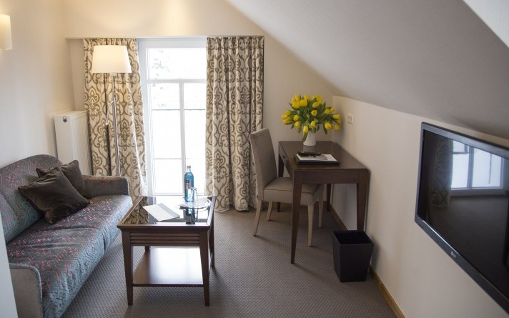 View into the living room of a single room Comfort with balcony at the Hotel Jagdhaus Wiese in the Sauerland
