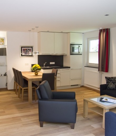 Das Wohn-Esszimmer mit Küchenzeile in der Ferienwohnung "Auf der Tenne" im zum Hotel Jagdhaus Wiese im Sauerland gehörenden Schneisberghaus ist hell und modern eingerichtet.