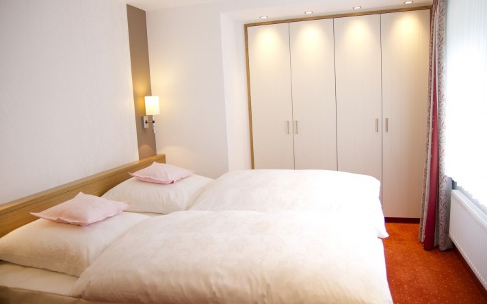 Slaapkamer van de vakantiewoning “Auf der Tenne” in het Schneisberghaus behorend bij Hotel Jagdhaus Wiese in het Sauerland