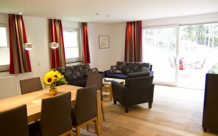 Een groot terras grenst aan de woonkamer van de vakantiewoning “Auf der Tenne” in het Schneisberghaus van Hotel Jagdhaus Wiese in het Sauerland.