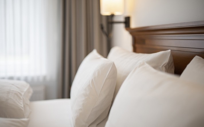 Bed met kussen in een exclusieve tuinsuite in Hotel Jagdhaus Wiese in het Sauerland