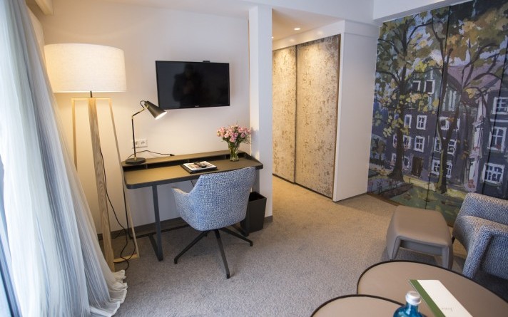 Living room with seating area and desk in a modern Classic suite at the Hotel Jagdhaus Wiese in the Sauerland region